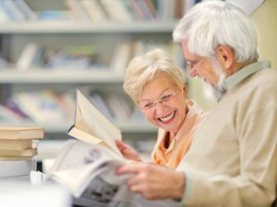 Imagem mostra dois idoso lendo livros